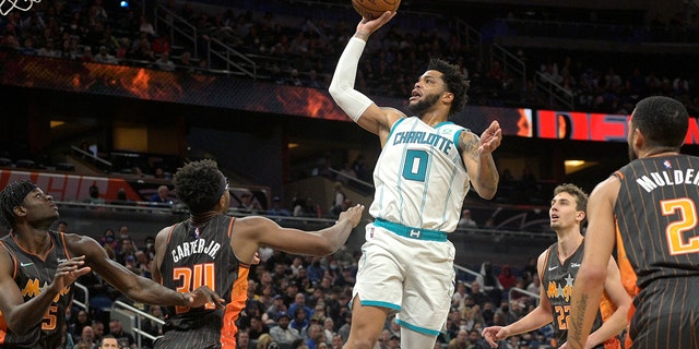 Charlotte Hornets forward Miles Bridges (0) goes up for a shot above Orlando Magic center Mo Bamba (5), center Wendell Carter Jr. (34), forward Franz Wagner (22) and guard Mychal Mulder (2) during the first half of a game Nov. 24, 2021, in Orlando, Fla.