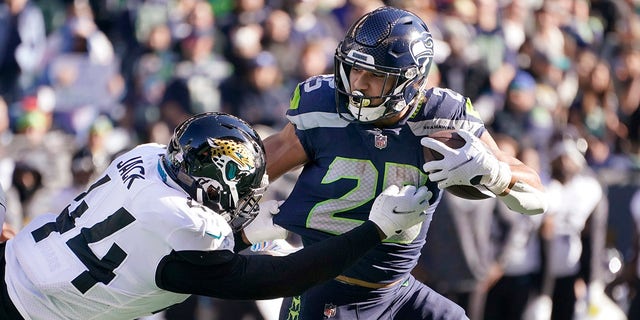 Seattle Seahawks' Travis Homer carries as Jacksonville Jaguars' Myles Jack defends during the first half of an NFL football game, Sunday, Oct. 31, 2021, in Seattle.