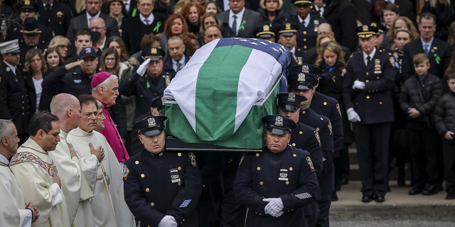 Police officers carry the remains of the fallen NYPD detective Brian Simonsen against a hearse after his funeral in the Church of St. Rosalie on February 20, 2019 in Hampton Bays, New York.