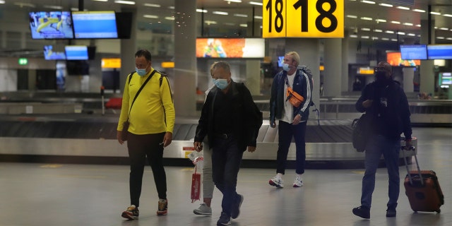 Pessoas entram no Aeroporto Schiphol em 27 de novembro de 2021, depois que autoridades de saúde holandesas disseram que 61 pessoas a bordo de voos da África do Sul para Amsterdã, na Holanda, tiveram teste positivo para Covit-19. 