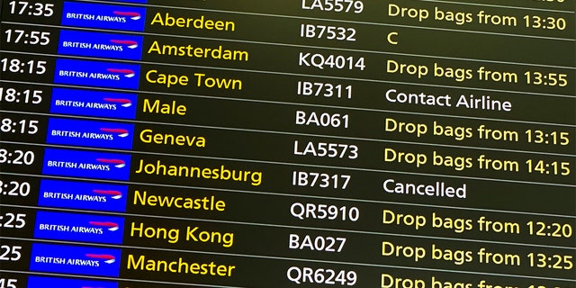 Un écran de départ affiche un vol annulé vers Johannesburg et un message pour contacter la compagnie aérienne pour un vol régulier vers Capetown, à l'aéroport Heathrow de Londres, le vendredi 26 novembre 2021.