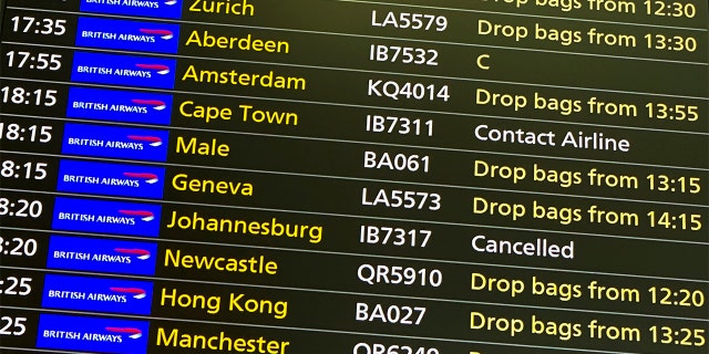 A departures screen displays a cancelled flight to Johannesburg and a message to contact the airline for a scheduled flight to Capetown, at London's Heathrow Airport, Friday, Nov. 26, 2021.