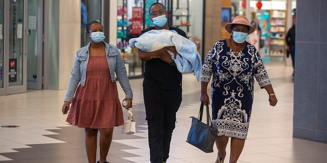 People with masks walik, at a shopping mall, in Johannesburg, South Africa, Friday Nov. 26, 2021.