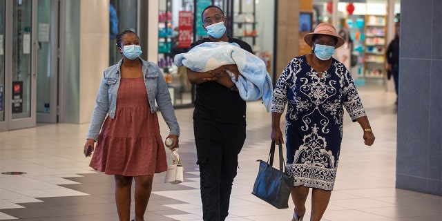 People with masks walik, at a shopping mall, in Johannesburg, South Africa, Friday Nov. 26, 2021.