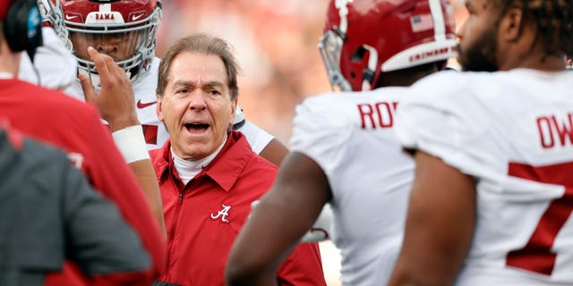 Alabama head coach Nick Saban talks with players in a time out during the first half of an NCAA college football game against Auburn Saturday, Nov. 27, 2021, in Auburn, Ala.
