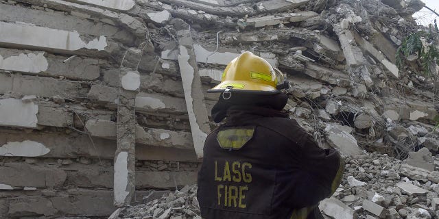 A fire fire fighter stand in the rubble of a 21-story building under construction that collapsed at Ikoyi district of Lagos, on Nov. 1.