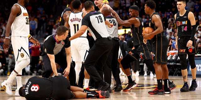 Markieff Morris (8) of the Miami Heat fell to the court after being hit by Nikola Jokic (15) of the Denver Nuggets at Ball Arena on Nov. 8, 2021 in Denver.