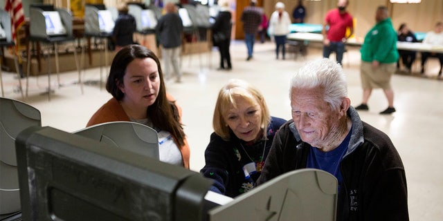 Cecil Moran, of Newark, receives some help casting his ballot on one of the electronic voting machines from poll workers Liz Worbs (left) and Anne Jones (middle) at the American Legion Post 85 on Election Day in Newark, Ohio on November 2, 2021.New 20211102 Early Voting 15
