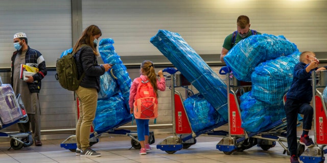 Les gens font la queue pour embarquer sur un vol outre-mer à l'aéroport OR Tambo de Johannesburg, en Afrique du Sud