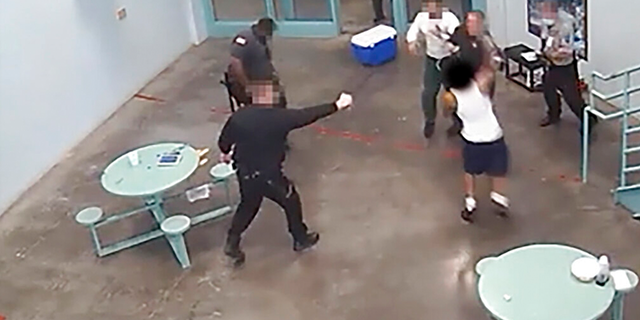 In this July 28, 2021 image made from a video taken by an overhead stationary security camera, guards at the Ohio State Penitentiary break up a fight between two inmates in Youngstown, Ohio.