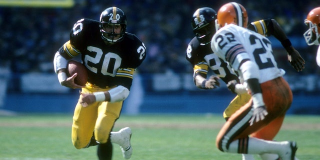 El corredor Rocky Bleier (20) of the Pittsburgh Steelers carries the ball looking to get a block from teammate Lynn Swann (88) on Clarence R. Scott (22) of the Cleveland Browns circa late 1970s during an NFL football game at Cleveland Municipal Stadium in Cleveland, Ohio. 
