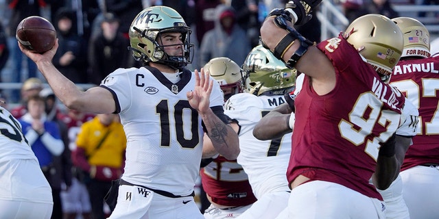 Wake Forest quarterback Sam Hartman (10) passes under pressure from Boston College defensive end Marcus Valdez (97) during the first half of an NCAA college football game, sábado, nov. 27, 2021, in Boston. 