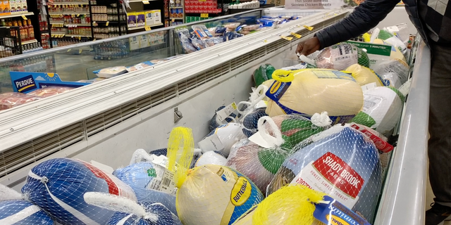 A shopper checks the price of frozen turkey