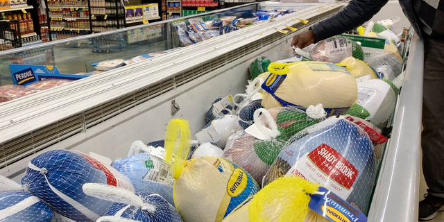 A shopper checks the price of frozen turkey