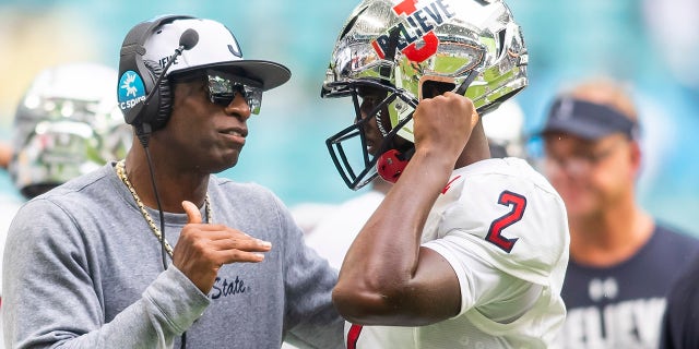 Jackson State Tigers head coach Deion Sanders speaks with Jackson State Tigers quarterback Shedeur Sanders (2) during the Orange Blossom Classic game between the Florida A and M Rattlers and the Jackson State Tigers Sept. 5, 2021 at Hard Rock Stadium in Miami Gardens, FL.