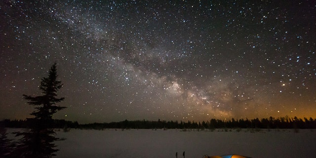 Tent camping under a rising Milky Way in Voyegeur's National Park in Minnesota.