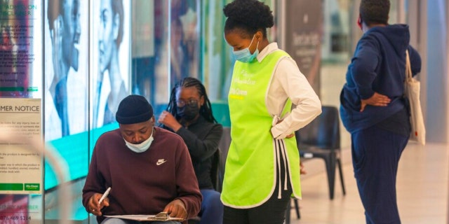 People line up to get vaccinated at a shopping mall in Johannesburg, South Africa, on Nov. 26, 2021. (AP Photo/Denis Farrell)