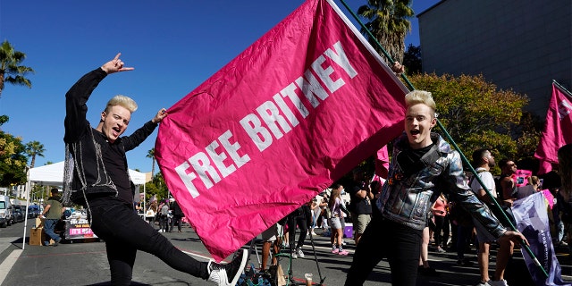 Twins Edward, right, and John Grimes of Dublin, Ireland, hold a ‘Free Britney’ flag outside a hearing concerning the pop singer's conservatorship at the Stanley Mosk Courthouse, Friday, Nov. 12, 2021, in Los Angeles.