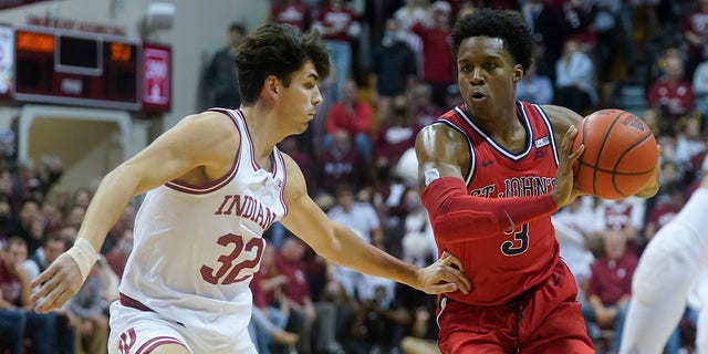 St. John's Stef Smith (3) makes a pass against Indiana's Trey Galloway (32) during the first half of an NCAA college basketball game, Wednesday, Nov. 17, 2021, in Bloomington, Indiana.