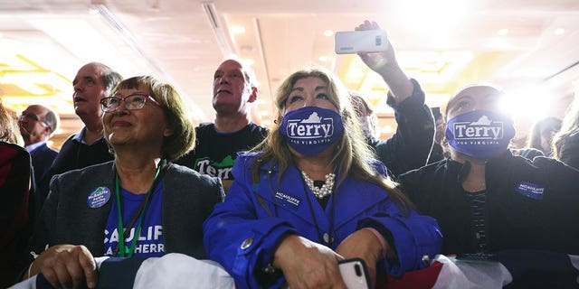 Supporters, some wearing 'Terry For Virginia' protective face masks, listen to Democratic nominee for Virginia Governor Terry McAuliffe speak during his election night party and rally in McLean, Virginia, U.S., November 2, 2021.