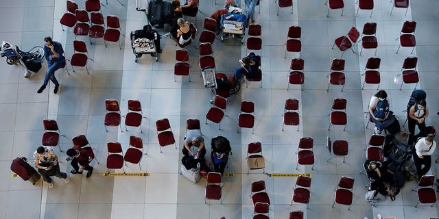 Travelers wait for documents checking, at the arrival terminal of Soekarno Hatta International airport, as the country bans the arrival of travellers who have been in eight African countries to curb the spread of the new omicron variant of the coronavirus, in Tangerang, near Jakarta, Indonesia, November 29, 2021. 