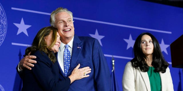 Democratic gubernatorial candidate Terry McAuliffe, 对, hugs his wife, 多萝西, as he makes an appearance at an election night party in McLean, 维吉尼亚州, 星期二, 十一月. 2, 2021. (AP Photo/Steve Helber)