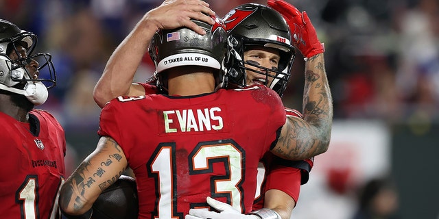 Tampa Bay Buccaneers wide receiver Mike Evans (13) hugs quarterback Tom Brady (12) after Evans caught a 5-yard touchdown pass during the second half of an NFL football game against the New York Giants on Monday, Nov. 22, 2021, in Tampa, Fla.