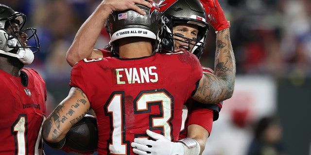 Tampa Bay Buccaneers wide receiver Mike Evans (13) hugs quarterback Tom Brady (12) after Evans caught a 5-yard touchdown pass during the second half of an NFL football game against the New York Giants on Monday, Nov. 22, 2021, in Tampa, Fla.