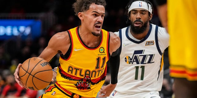 Atlanta Hawks guard Trae Young (11) dribbles past Utah Jazz guard Mike Conley (11) during the first quarter Nov. 4, 2021, at State Farm Arena in Atlanta, Ga.