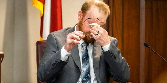Travis McMichael reacts to questions during his testimony in the trial of he and his father Greg McMichael and neighbor William "Roddie" Bryan in the Glynn County Courthouse, Wednesday, Nov. 17, 2021, in Brunswick, Ga. (AP Photo/Stephen B. Morton, Pool)
