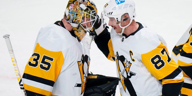 Pittsburgh Penguins captain Sidney Crosby celebrates with teammate goaltender Tristan Jarry after their victory over the Montreal Canadiens in NHL hockey game action in Montreal, Thursday, Nov. 18, 2021. 