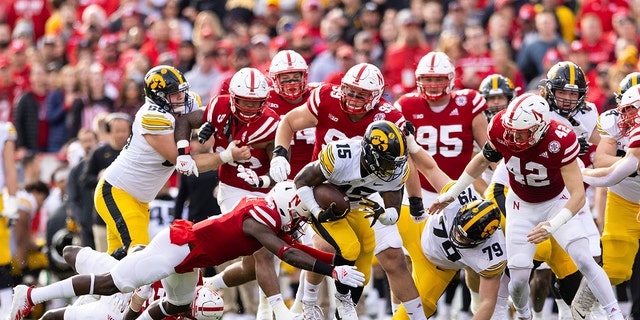 Iowa's Tyler Goodson (15) carries the ball as Nebraska's Marquel Dismuke (9) dives for the tackle during the first half of a game Nov. 26, 2021, at Memorial Stadium in Lincoln, Neb.