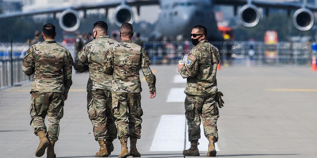 U.S. military personnel walk on the tarmac at the Seoul International Aerospace and Defense Exhibition in Seongnam, South Korea, south of Seoul, on Oct. 18, 2021.