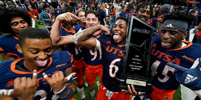 UTSA players celebrate with their conference trophy after their win over UAB Saturday, Nov. 20, 2021, in San Antonio.