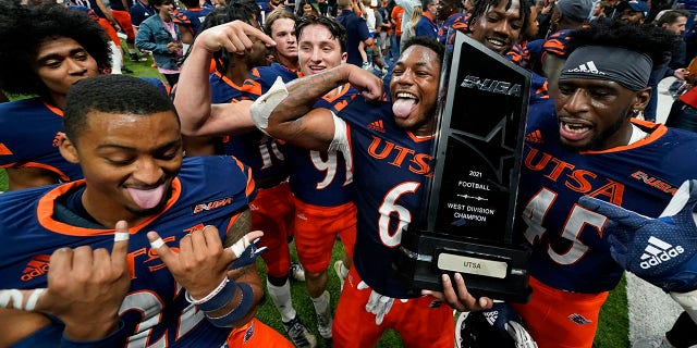 UTSA players celebrate with their conference trophy after their win over UAB Saturday, Nov. 20, 2021, in San Antonio.