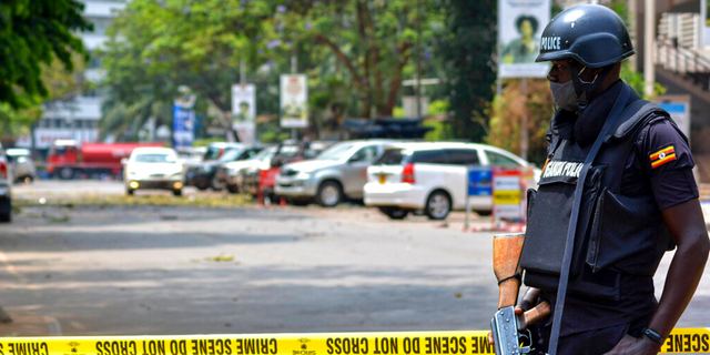 Security forces secure the scene of a blast on a street near the parliamentary building in Kampala, Uganda, Tuesday, Nov. 16, 2021. Two loud explosions rocked Uganda's capital, Kampala, early Tuesday, sparking chaos and confusion as people fled what is widely believed to be coordinated attacks. (AP Photo/Hajarah Nalwadda) 