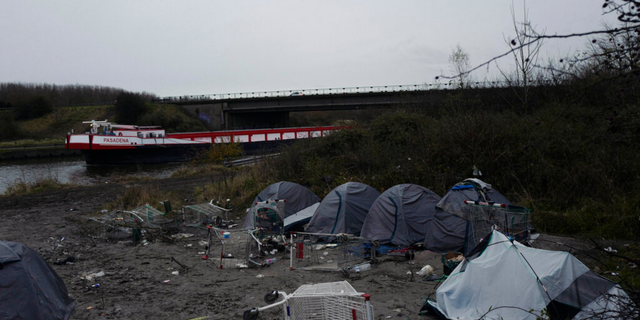A migrants makeshift camp is set up along the river in Loon Plage, near Grande-Synthe, northern France, Friday, Nov. 26, 2021. Children and pregnant women were among at least 27 migrants who died when their small boat sank in an attempted crossing of the English Channel, a French government official said Thursday.