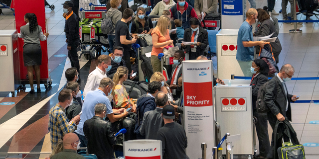 Les gens font la queue pour embarquer sur le vol Air France à destination de Paris à l'aéroport international OR Tambo de Johannesburg, Afrique du Sud, le vendredi 26 novembre 2021. Un grand nombre de pays ont décidé d'arrêter les voyages aériens en provenance d'Afrique australe vendredi en réaction à l'annonce d'un nouvelle variante de COVID-19 potentiellement plus transmissible qui a été détectée en Afrique du Sud.  Les scientifiques disent que c'est une préoccupation en raison de son nombre élevé de mutations et de sa propagation rapide parmi les jeunes du Gauteng, la province la plus peuplée du pays. 