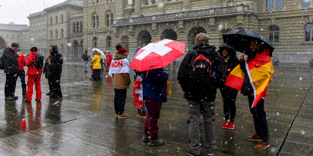 Menschen protestieren während einer Kundgebung für Gegner des COVID-19-Gesetzes in Bern, Schweiz, am Sonntag, 28. November 2021. Es scheint, dass die Schweizer Wähler einem klaren Randgesetz zustimmen werden, das ein spezielles COVID-19-Zertifikat eingeführt hat, das nur Personen erlaubt, die geimpft, genesen oder negativ getestet wurden, um an öffentlichen Veranstaltungen und Versammlungen teilzunehmen.  (Anthony Annex/Keystone über The Associated Press)