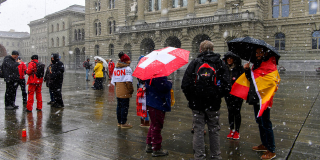 Menschen protestieren während einer Kundgebung für Gegner des COVID-19-Gesetzes in Bern, Schweiz, am Sonntag, 28. November 2021. Es scheint, dass die Schweizer Wähler einem klaren Randgesetz zustimmen werden, das ein spezielles COVID-19-Zertifikat eingeführt hat, das nur Personen erlaubt, die geimpft, genesen oder negativ getestet wurden, um an öffentlichen Veranstaltungen und Versammlungen teilzunehmen. (Anthony Annex/Keystone über The Associated Press)