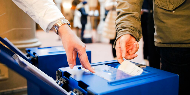 Die Stimmberechtigten haben am Sonntag, 28. November 2021, in einem Wahllokal im Zürcher Rathaus in Zürich, Schweiz, ihre Stimme für drei nationale Gesetzesentwürfe, darunter ein COVID-19-Gesetz und mehrere kantonale und kommunale Vorschläge, abgegeben. Genehmigung durch klare Randgesetzgebung eingeführt Ein spezielles COVID-19-Zertifikat, das es nur Personen erlaubt, die geimpft, genesen oder negativ getestet wurden, an öffentlichen Veranstaltungen und Versammlungen teilzunehmen.  (Michael Buholzer/Keystonve über AP)