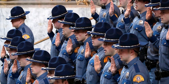 New Washington State Patrol troopers taking part in a graduation ceremony raise their right hands and take the Oath of Office, 星期四, 十二月. 13, 2018, in the Rotunda at the Capitol in Olympia, 洗.