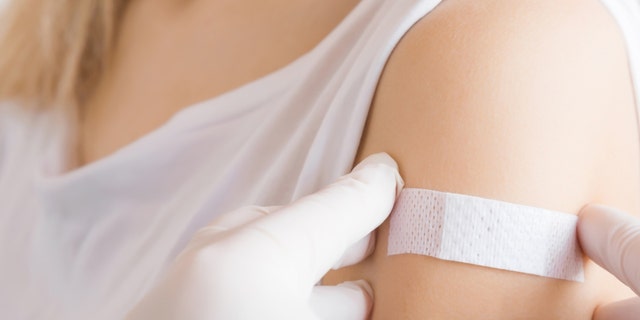 The woman is shown with a bandage on her arm, where she received her inoculation.  The oral polio vaccine has not been used in the US since 2000.
