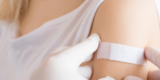 A woman is shown having a bandage put over her arm where she received a vaccination. The oral vaccine for polio has not been in use in the U.S. since the year 2000.