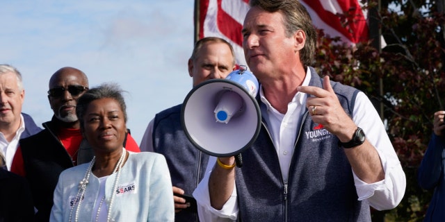 Republican gubernatorial candidate Glenn Youngkin, right, speaks to supporters as Lt. Gov. candidate Winsome Sears, left, listens during a rally in Fredericksburg, Va., Saturday, Oct. 30, 2021. Youngkin will face Democrat former Gov. Terry McAuliffe in the November election. (AP Photo/Steve Helber)