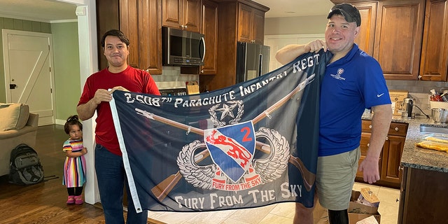 Johnny holds 508th Infantry Regiment flag with wounded veteran Mike Verardo.