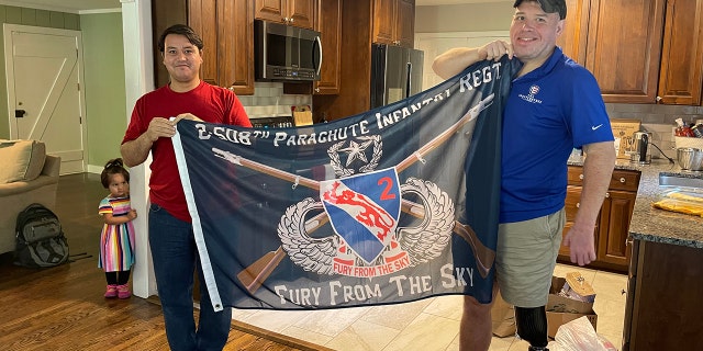 Johnny holds 508th Infantry Regiment flag with wounded veteran Mike Verardo.