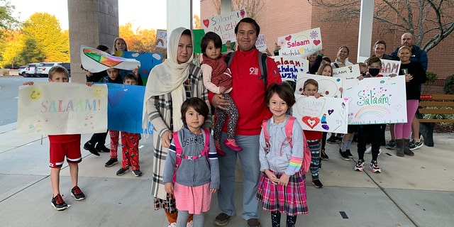 Classmates and local families greet daughters of Afghan interpreter.