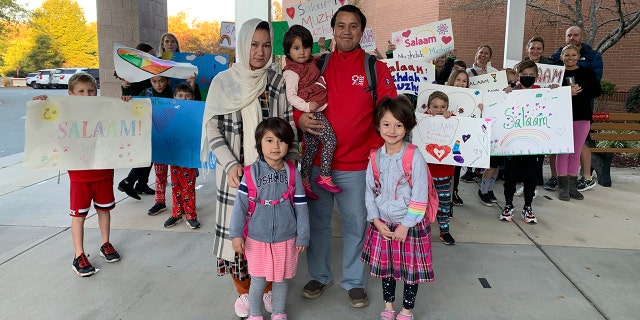 Classmates and local families greet daughters of Afghan interpreter.