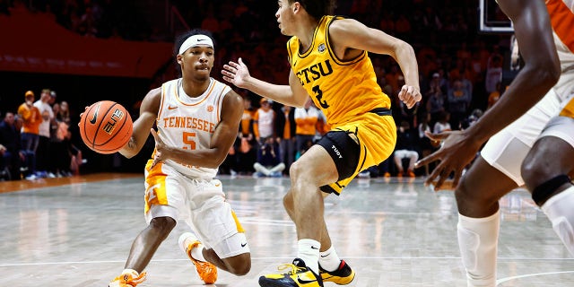Tennessee guard Zakai Zeigler (5) passes the ball as he's defended by East Tennessee State guard Jordan King (2) during an NCAA college basketball game, Sunday, Nov. 14, 2021, in Knoxville, Tenn.